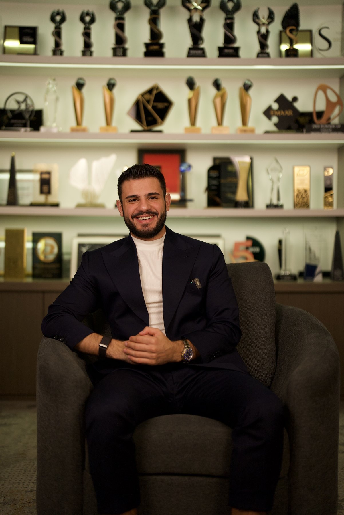 Wissam Baradhi seated in his office in front of a wall of real estate awards